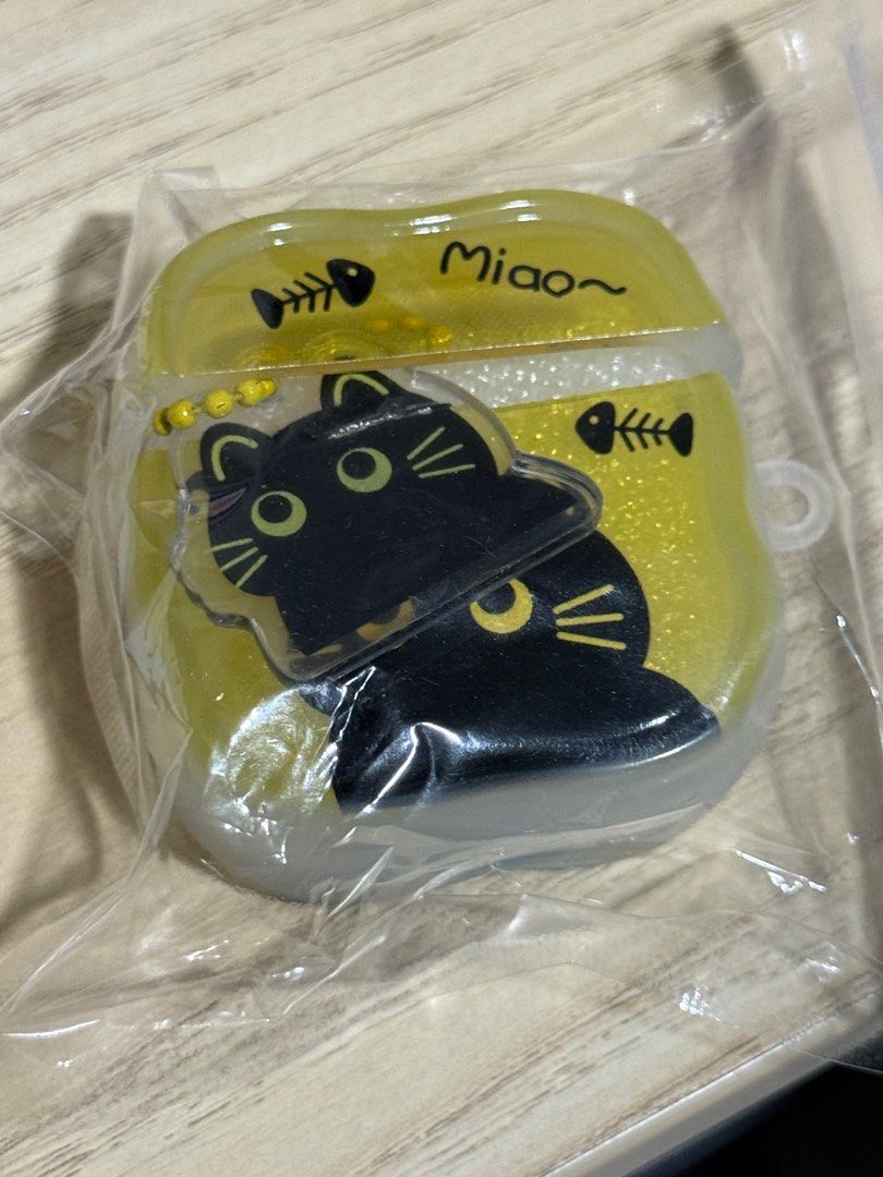Cute Cat AirPods Case (Category: Cases & Sleeves) located in Singapore. Submitted by mintychococat (Listing ID 1387673576, Image 2). Description: - Brand new AirPods case - Features a cute black cat design - Glittery yellow background - 'Miao' text and fishbone accents - Comes in original packaging - Protects your AirPods in style! - Silicone - Comes with a little black cat tag - 1pc only - $13 - Meetup only (arrange with Seller on meetup locatio