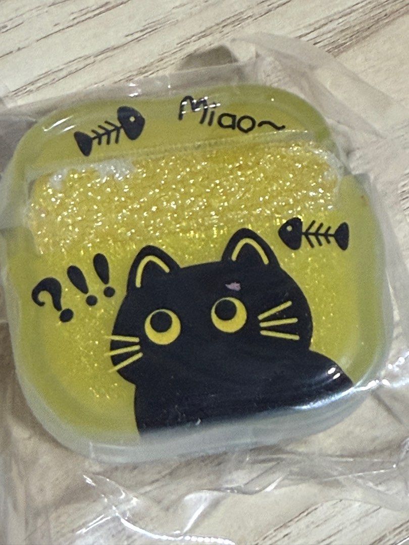 Cute Cat AirPods Case (Category: Cases & Sleeves) located in Singapore. Submitted by mintychococat (Listing ID 1387673576, Image 1). Description: - Brand new AirPods case - Features a cute black cat design - Glittery yellow background - 'Miao' text and fishbone accents - Comes in original packaging - Protects your AirPods in style! - Silicone - Comes with a little black cat tag - 1pc only - $13 - Meetup only (arrange with Seller on meetup locatio