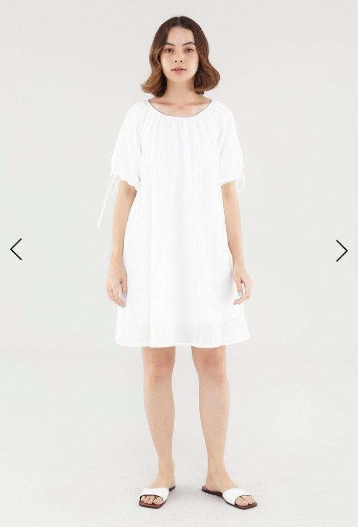 TEM Luna puff-sleeve dress in white (Category: Dresses) located in Singapore. Submitted by kolyacircles (Listing ID 1414498203, Image 2). Description: - White mini dress - Wide neckline - Short puffed sleeves with tie-straps - Back keyhole opening with loop button closure - Relaxed trapeze silhouette - Fabric: 83% Lyocell, 17% Cotton - Designed for a relaxed fit.