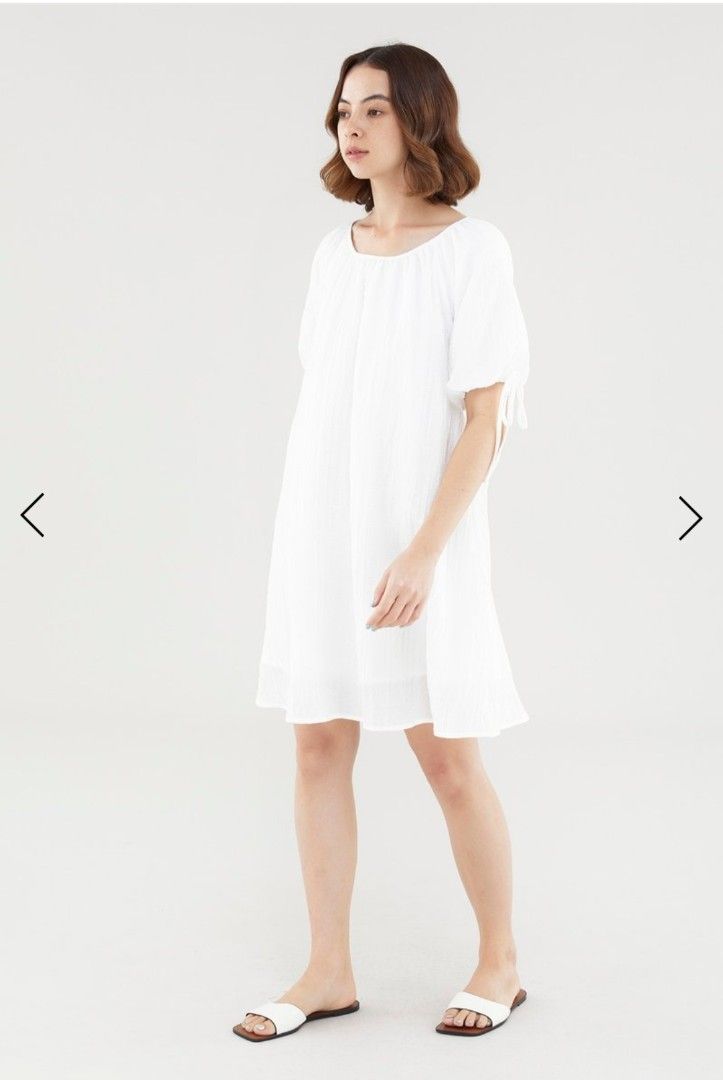 TEM Luna puff-sleeve dress in white (Category: Dresses) located in Singapore. Submitted by kolyacircles (Listing ID 1414498203, Image 1). Description: - White mini dress - Wide neckline - Short puffed sleeves with tie-straps - Back keyhole opening with loop button closure - Relaxed trapeze silhouette - Fabric: 83% Lyocell, 17% Cotton - Designed for a relaxed fit.