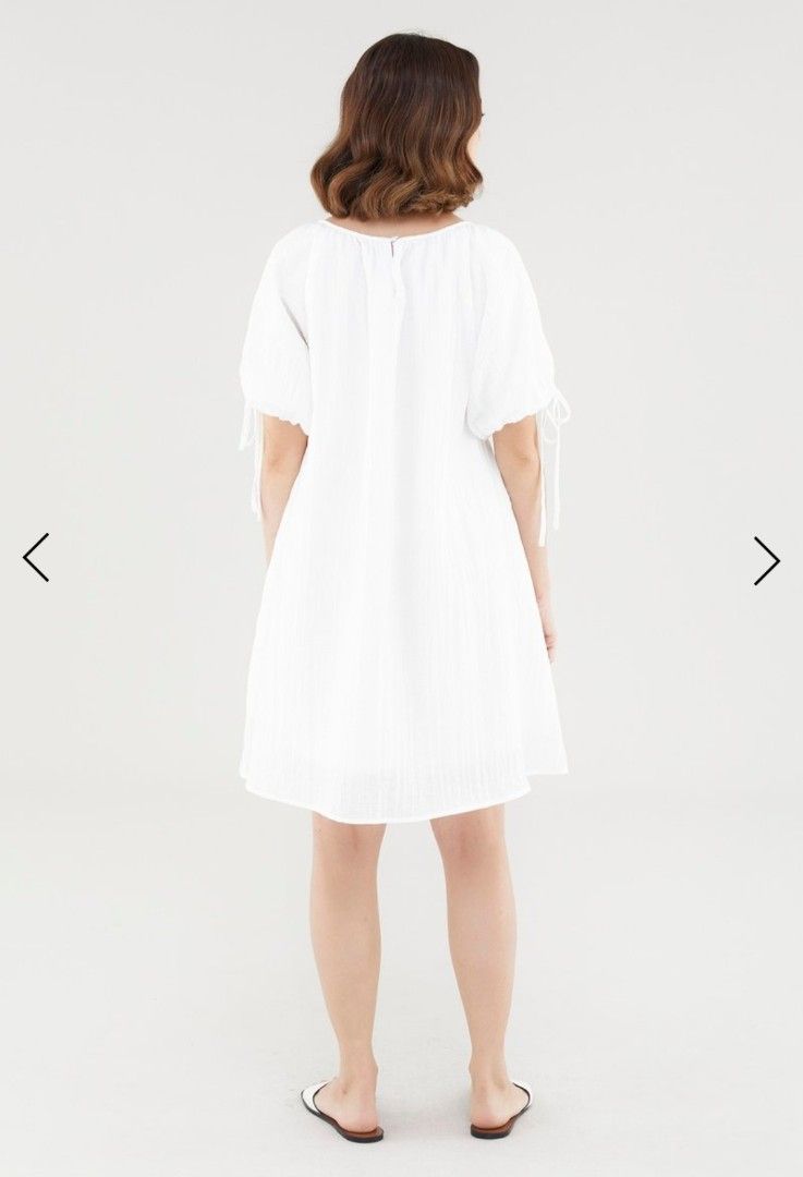 TEM Luna puff-sleeve dress in white (Category: Dresses) located in Singapore. Submitted by kolyacircles (Listing ID 1414498203, Image 3). Description: - White mini dress - Wide neckline - Short puffed sleeves with tie-straps - Back keyhole opening with loop button closure - Relaxed trapeze silhouette - Fabric: 83% Lyocell, 17% Cotton - Designed for a relaxed fit.