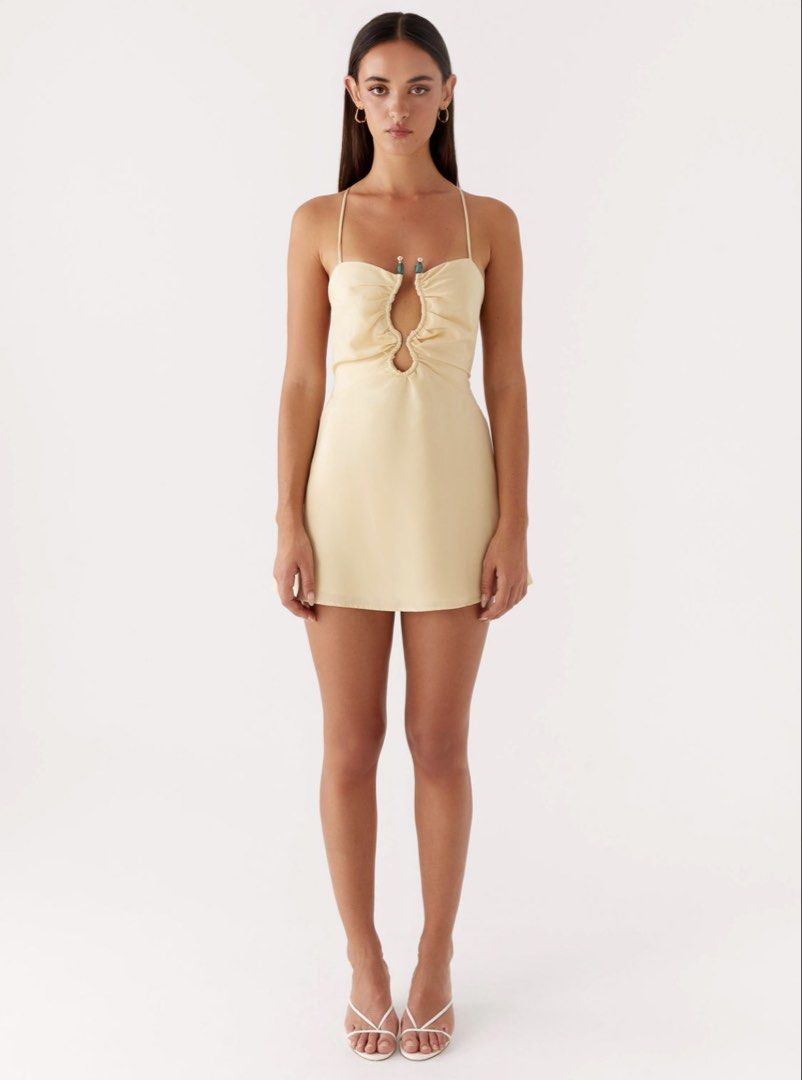 BNWT Peppermayo Zuma Mini Dress in Yellow (Category: Dresses) located in Singapore. Submitted by fri.es (Listing ID 1424077282, Image 1). Description: Peppermayo Exclusive The Zuma Mini Dress is edgy and captivating, designed to turn heads. Featuring a bold front cutout and metal accents, it blends daring details with a sleek silhouette. - Mini length - Front cut out and metal embellishment - Thin straps - Back criss-cross tie strap - Fully lined