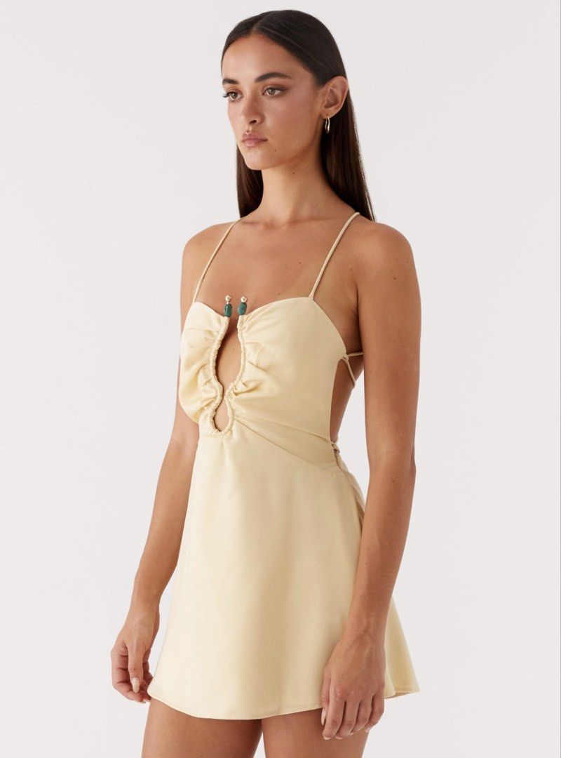 BNWT Peppermayo Zuma Mini Dress in Yellow (Category: Dresses) located in Singapore. Submitted by fri.es (Listing ID 1424077282, Image 2). Description: Peppermayo Exclusive The Zuma Mini Dress is edgy and captivating, designed to turn heads. Featuring a bold front cutout and metal accents, it blends daring details with a sleek silhouette. - Mini length - Front cut out and metal embellishment - Thin straps - Back criss-cross tie strap - Fully lined