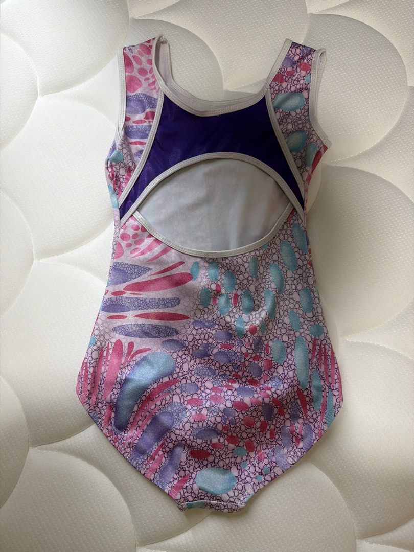 Girls' Gymnastics Leotard - Pink, Purple, and Blue (Category: Babies & Kids Fashion) located in Singapore. Submitted by cassandrahan (Listing ID 1433061165, Image 2). Description: - total length 57cm - Features a vibrant pattern with pink, purple, and blue accents. - Unique open back design with a purple panel. - Ideal for gymnastics or dance practice. .