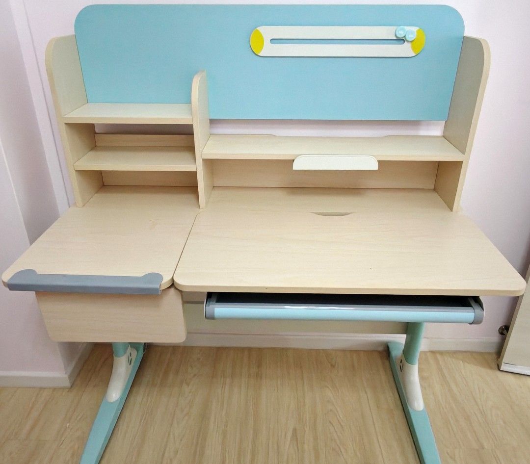 (Used) Kids Study Table (No Chair) (Category: Tables & Sets) located in Singapore. Submitted by junebug (Listing ID 1441399163, Image 1). Description: Used kids study table. Wooden top with metal bottom frame. Comes with stationery tray below the tabletop, small drawer at the side and a book/tablet holder. No chair included. Table height is adjustable manually using the detachable lever provided. Table can also be lifted to 3 different angles. Si