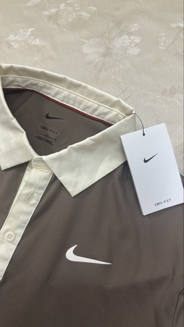 Nike Dri-FIT Golf Polo Shirt - Men's Large - Grey (Category: Tshirts & Polo Shirts) located in Singapore. Submitted by yassha (Listing ID 1450301378, Image 2). Description: - Grey Nike Dri-FIT Polo Shirt - Size: L - Features a light cream collar and white buttons - Iconic Nike swoosh logo on the chest - Material: 88% Polyester, 12% Spandex - Ideal for golf or everyday casual wear.