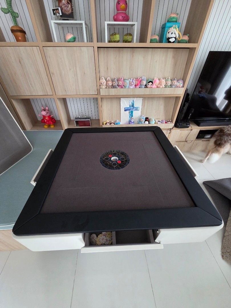 Automatic Mahjong Table with Built-in chips storage (Category: Tables & Sets) located in Singapore. Submitted by rexeter (Listing ID 1450455395, Image 2). Description: - Foldable Mahjong Table - Dark Brown Fabric Surface - Black Frame & White Casing - Built-in Storage Compartments for Tiles & Accessories - Folds Neatly for Easy Storage - Ideal for Game Nights.