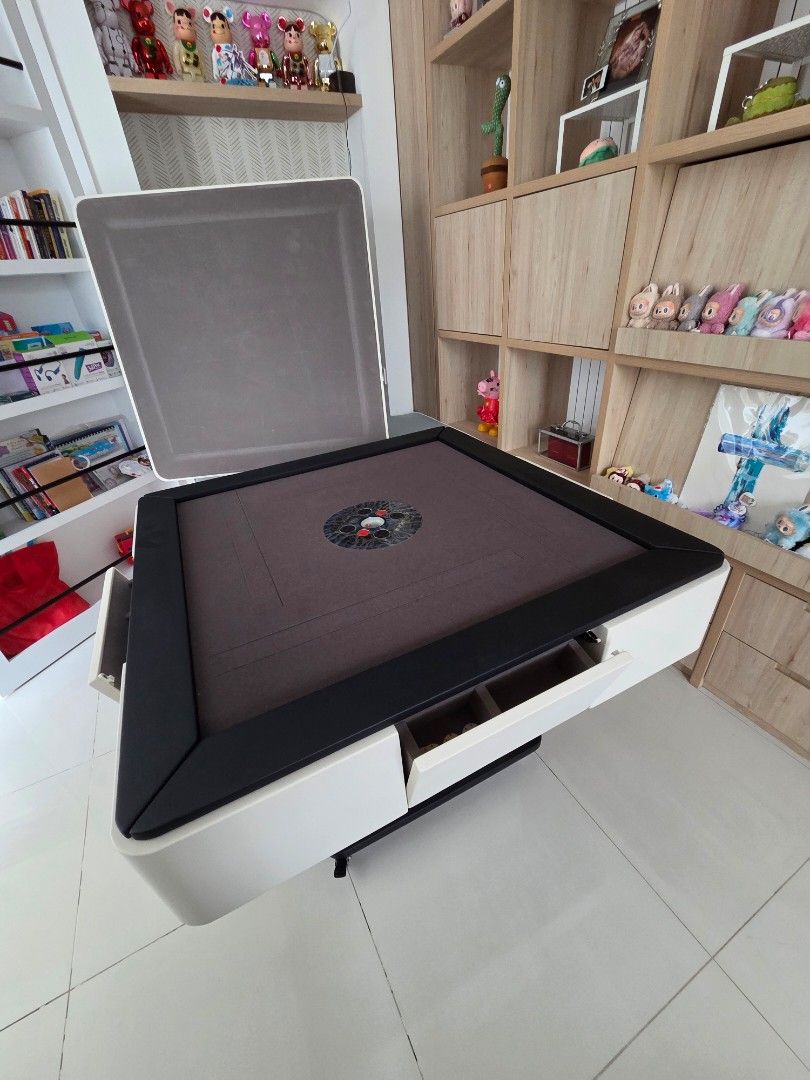 Automatic Mahjong Table with Built-in chips storage (Category: Tables & Sets) located in Singapore. Submitted by rexeter (Listing ID 1450455395, Image 4). Description: - Foldable Mahjong Table - Dark Brown Fabric Surface - Black Frame & White Casing - Built-in Storage Compartments for Tiles & Accessories - Folds Neatly for Easy Storage - Ideal for Game Nights.