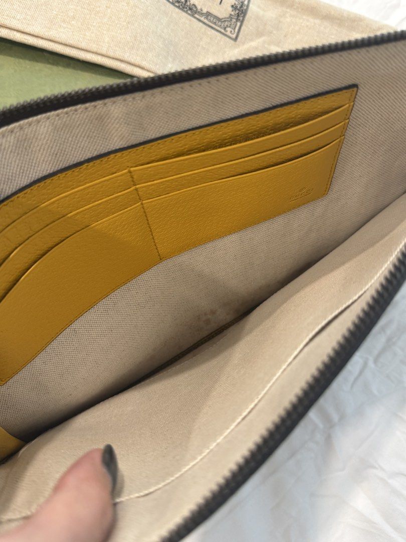 Gucci GG Supreme Monogram Clutch with Tiger Head (Category: Bags & Wallets) located in Singapore. Submitted by heysoul555 (Listing ID 1447369176, Image 7). Description: - Authentic Gucci clutch - Classic GG Supreme canvas - Signature tiger head detail - 'GUCCI' lettering on oval patch - Yellow leather wrist strap - Interior card slots - Includes original box - Includes dust bag.