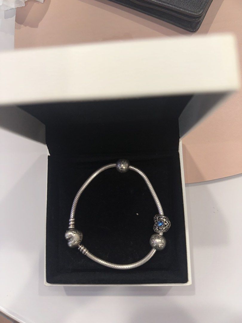 Pandora Sterling Logo Heart Clasp Silver Bracelet with December Blue Signature Heart Crystal Charms (Category: Bracelets) located in Singapore. Submitted by whitespade_ (Listing ID 1453181644, Image 3). Description: - Genuine Pandora sterling silver bracelet - Features a beautiful heart clasp - Includes 3 charms: 1 blue-stoned heart charm, 2 small silver ball charms - Ideal for expanding your Pandora collection or starting a new one - Sold as a c