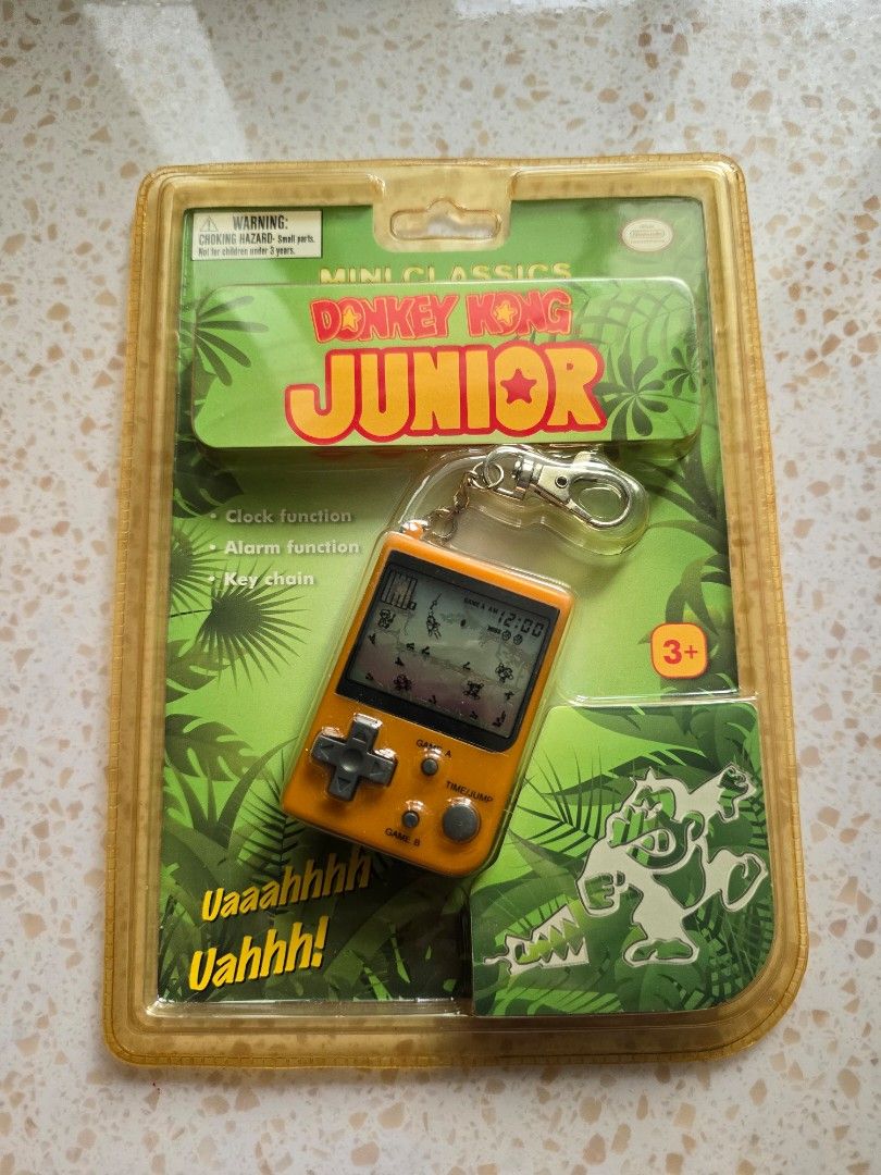 Game & Watch - Donkey Kong Junior (Category: Interactive Toys) located in Singapore. Submitted by ButterCup (Listing ID 1455942890, Image 4). Description: - Nintendo Game & Watch Mini Classics - Features Donkey Kong Junior - Original packaging included - Orange handheld console - Functions as a game, clock, and alarm - Can be used as a keychain - Collectible retro gaming item.