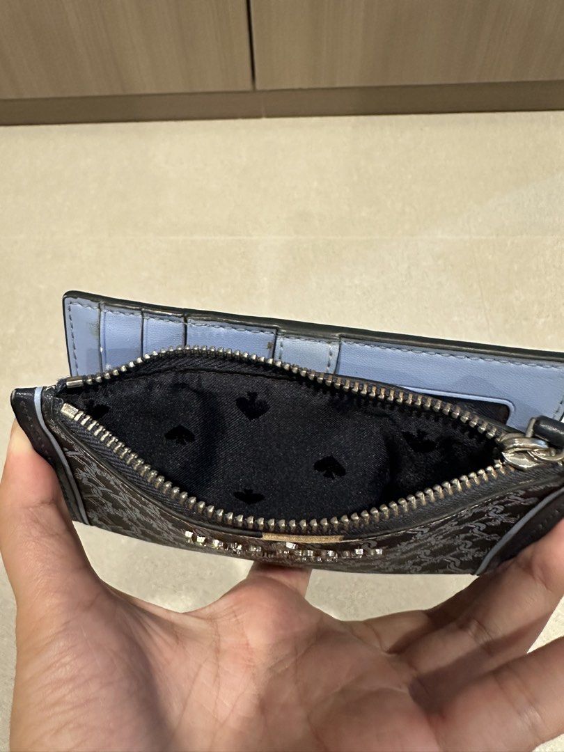Kate Spade Blue link patterned lock bi fold card holder wallet (Category: Wallets & Card Holders) located in Singapore. Submitted by whitespade_ (Listing ID 1456009460, Image 6). Description: - Brand: Kate Spade - Type: Bi-fold card holder wallet - Design: Blue link pattern with gold 'Kate Spade New York' logo - Interior: Multiple card slots, clear ID window, zippered compartment, able to put coins and cards - Color: Blue and navy - Features: Com
