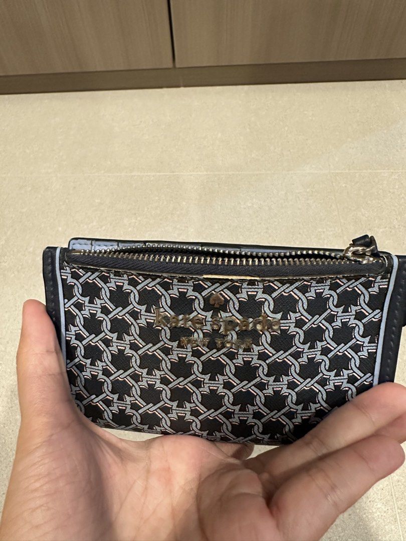Kate Spade Blue link patterned lock bi fold card holder wallet (Category: Wallets & Card Holders) located in Singapore. Submitted by whitespade_ (Listing ID 1456009460, Image 7). Description: - Brand: Kate Spade - Type: Bi-fold card holder wallet - Design: Blue link pattern with gold 'Kate Spade New York' logo - Interior: Multiple card slots, clear ID window, zippered compartment, able to put coins and cards - Color: Blue and navy - Features: Com