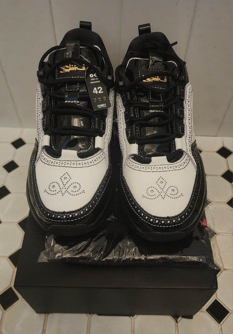 STAPLE x Sbtg x Kanky (Category: Sneakers) located in Singapore. Submitted by jemwong (Listing ID 1456141394, Image 2). Description: - Brand: STAPLE x SBTG x Kanky - Size: EU 42 (Men's Footwear) - Color: Black and White - Design: Classic silhouette with a mix of patent finishes, detailed stitching, and perforated accents. - Condition: BNIB - Features: Unique collaboration piece. - Meetup Location: Skyparc@Dawson (Blk 96 Dawson Road, 141096) Viewi