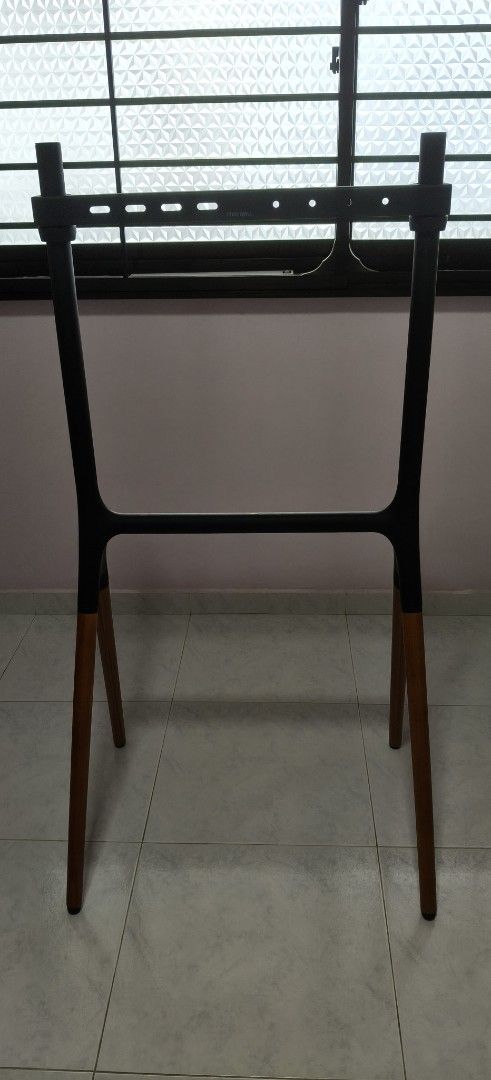 Edgewall TV Stand (Category: TV Consoles) located in Singapore. Submitted by octarnab (Listing ID 1453329582, Image 2). Description: - Edgewall TV stand: EdgeM Arte Floor Easel Art Stand - Sleek black metal frame with stylish wooden legs - Very stable. can hold up to 40kg and 70 inch TV - Condition 9.5/10 - I only have the top horizontal bracket for this TV stand. there's supposed to be a bottom bracket that offers slightly more support and stabi
