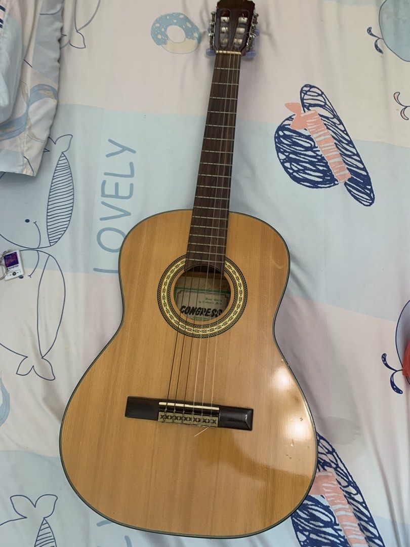 Congress Classical Guitar with Bag (Category: Musical Instruments) located in Singapore. Submitted by ukiyoscript (Listing ID 1456628846, Image 2). Description: - Congress classical guitar - Natural wood finish - Nylon strings - Includes black guitar bag (note: some tears) - Ideal for beginners or casual playing - Pickup only - Open to nego.