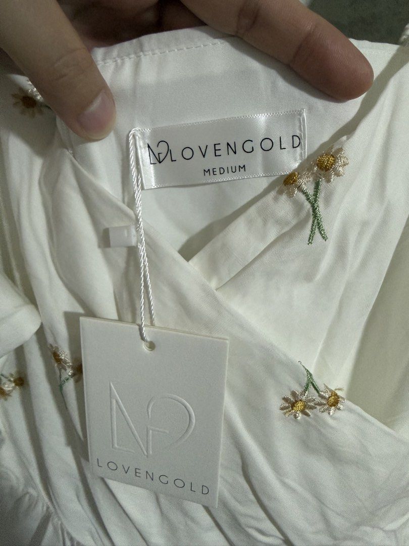 Lovengold White Puff Sleeve Midi Dress with Daisy Embroidery (Category: Dresses) located in Singapore. Submitted by ps1988 (Listing ID 1457186678, Image 2). Description: - Brand: Lovengold - Color: White - Style: Midi Dress - Size: M - Features: Puff sleeves, sweetheart neckline, all-over daisy embroidery, elasticated waist, ruffled hemline - Occasion: Perfect for summer outings.