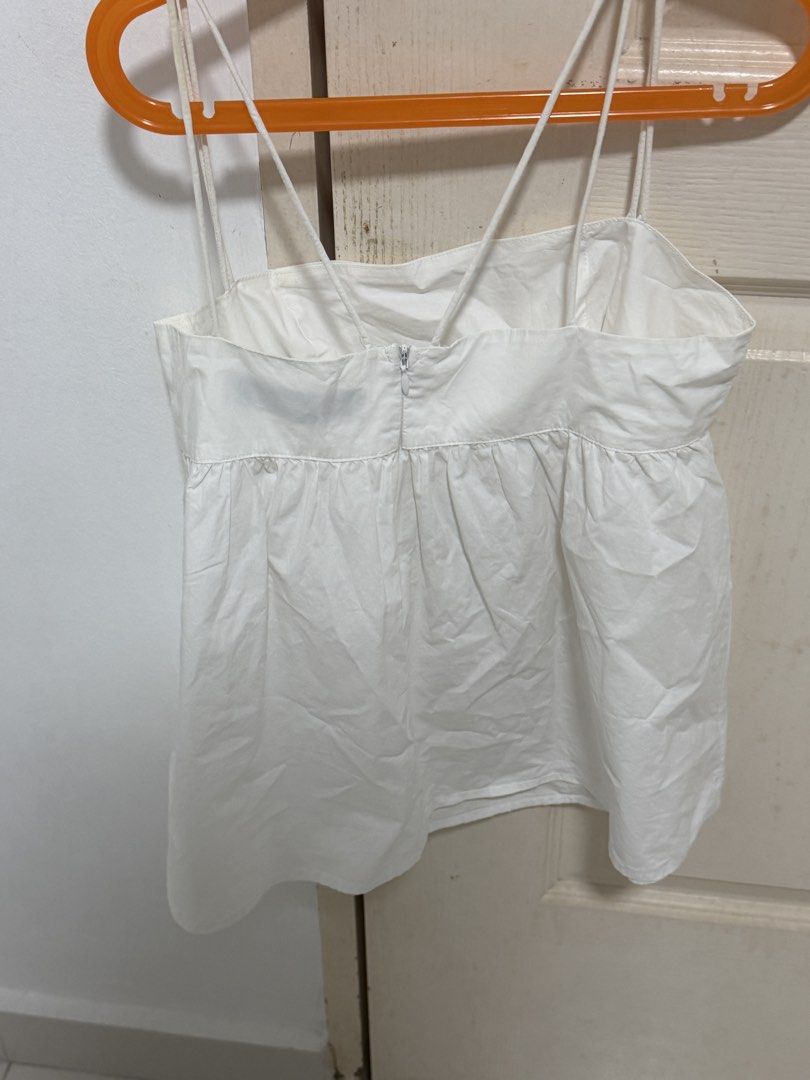 The Editor's Market White Spaghetti Strap Babydoll Top (Category: Sleeveless) located in Singapore. Submitted by geezck06 (Listing ID 1457292180, Image 2). Description: - White babydoll top from The Editor's Market - Spaghetti straps with criss-cross back detail - Zipper closure at the back - Flattering gathered waist - Easy to style for casual or dressy occasions - Great for summer - Thrifted from thryft but never won before - Self collect from 