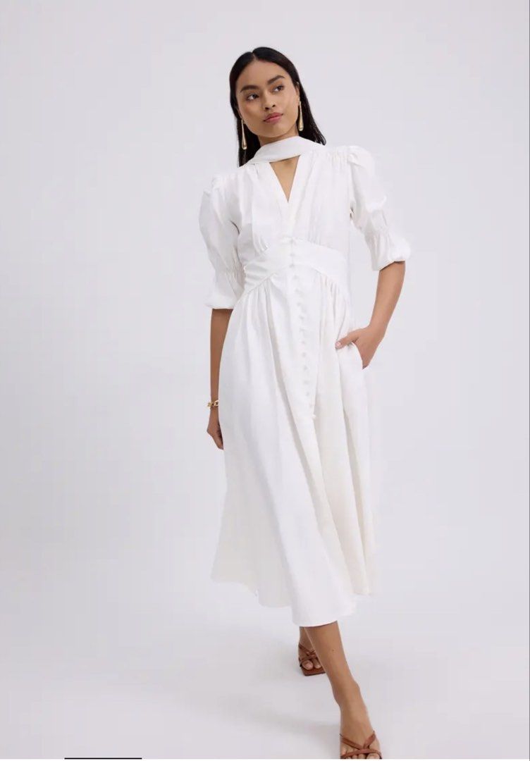 Love Bonito White Puff Sleeve Midi Dress with Button Detail (Category: Dresses) located in Singapore. Submitted by waddleofjoy (Listing ID 1457600858, Image 1). Description: - White midi dress - Puff sleeves - V-neckline - Button-down front - Cinched waist - Flowy A-line skirt - Functional pockets - Ideal for events or casual chic outings.