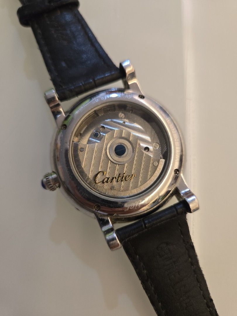 Automatic Watch with Leather Strap (Category: Men's Watches) located in Singapore. Submitted by urban.trader (Listing ID 1458056027, Image 4). Description: - Cartier automatic watch - Visible balance wheel showcasing the movement - Classic Roman numeral dial - Day and year is static - Date is working. - Comes with a blue leather strap and buckle - Exhibition case back to view the movement.