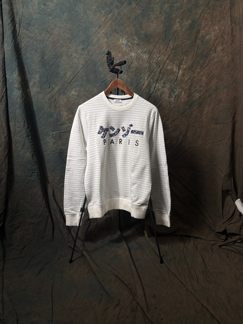 MENS KENZO PARIS Striped Sweatshirt (Category: Longsleeves) located in Singapore. Submitted by supsg (Listing ID 1458211095, Image 1). Description: - White and grey striped sweatshirt - Features 'Kenzo Paris' graphic on front - Long sleeves - Crew neck - Comfortable fit - Ideal for casual wear.