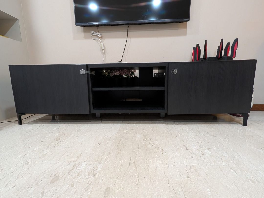 Black TV Console Cabinet with Storage (Category: TV Consoles) located in Singapore. Submitted by apracho1987 (Listing ID 1458840575, Image 1). Description: Move-out sale! Sleek and modern black TV console with two side cabinets for concealed storage and a two-tier open shelf in the centre for easy access to media devices and accessories. Features slim black legs, generous storage space, and a versatile minimalist design that complements most livi