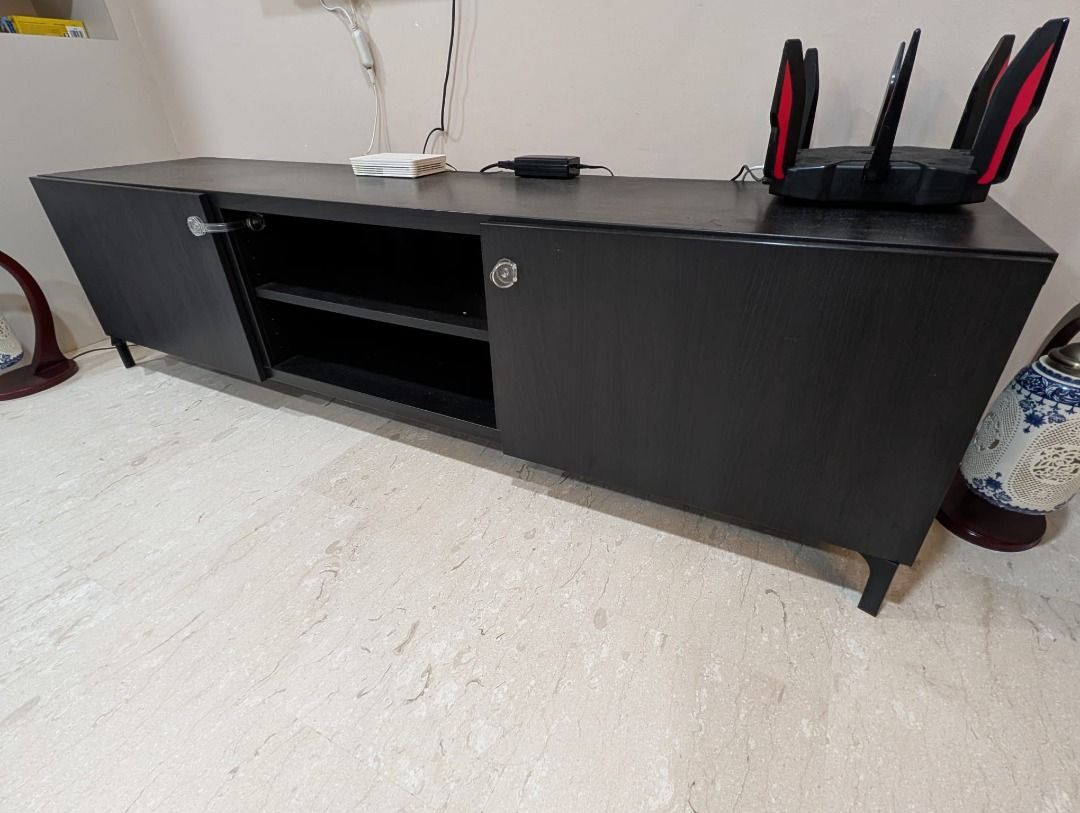 Black TV Console Cabinet with Storage (Category: TV Consoles) located in Singapore. Submitted by apracho1987 (Listing ID 1458840575, Image 2). Description: Move-out sale! Sleek and modern black TV console with two side cabinets for concealed storage and a two-tier open shelf in the centre for easy access to media devices and accessories. Features slim black legs, generous storage space, and a versatile minimalist design that complements most livi
