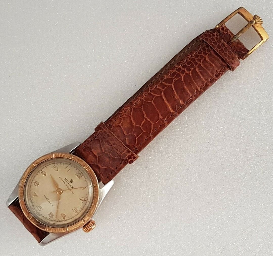 Vintage 1950’s Rolex Speed King Wristwatch, SWISS Made, Distinctive Engine-Turned Bezel, Caliber 5021, Manual Winding Watch, 18 Rubies, Retro 2-Tone Design, Oyster Precision, Tropical Dial, Timeless Classic, Luxury Timepiece, For Collectors, Hobbyists (Category: Watches) located in Singapore. Submitted by discountshop (Listing ID 1453691641, Image 2). Description: The Rolex Speed King is a vintage, manually wound midsize watch, Rolex Oyster Speed