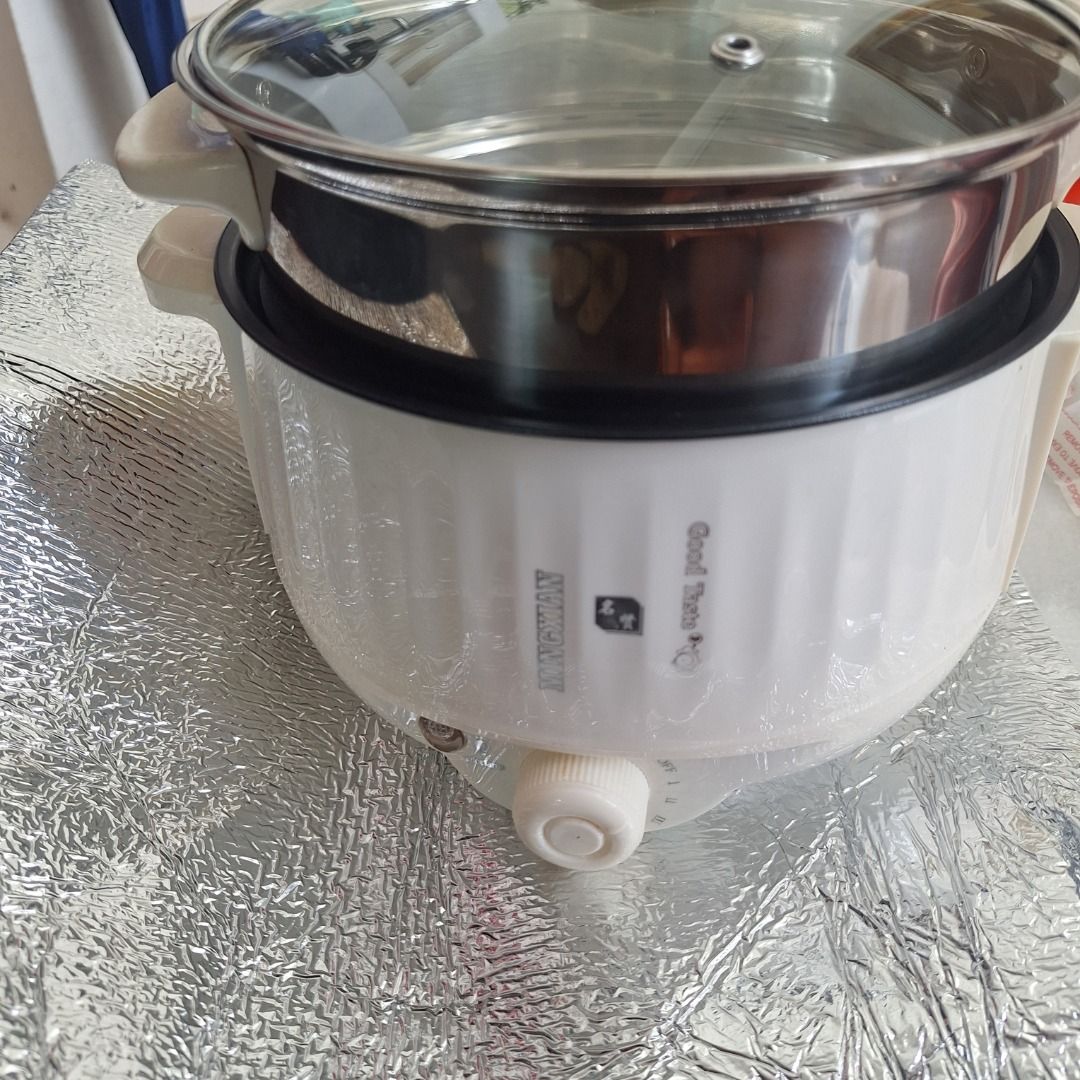 Good Taste Electric Pot Steamer (Category: Cookware & Accessories) located in Singapore. Submitted by jessicaleekoksim (Listing ID 1458924688, Image 1). Description: - White electric pot - Includes steamer insert - Features a glass lid - Adjustable heat control dial - Ideal for cooking and steaming - Compact size for easy storage - Perfect for preparing small meals.
