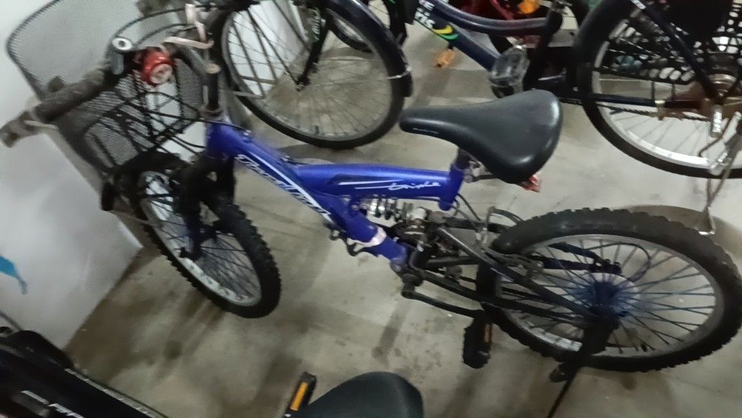 Blue Full Suspension Mountain Bike with Basket (Category: Bicycles) located in Singapore. Submitted by sdconstuc (Listing ID 1459330012, Image 1). Description: - Blue full suspension mountain bike - Includes front basket and bell - Tires show some wear - Frame has scuffs and scratches - Ready for a new rider - Suitable for trails and casual rides.